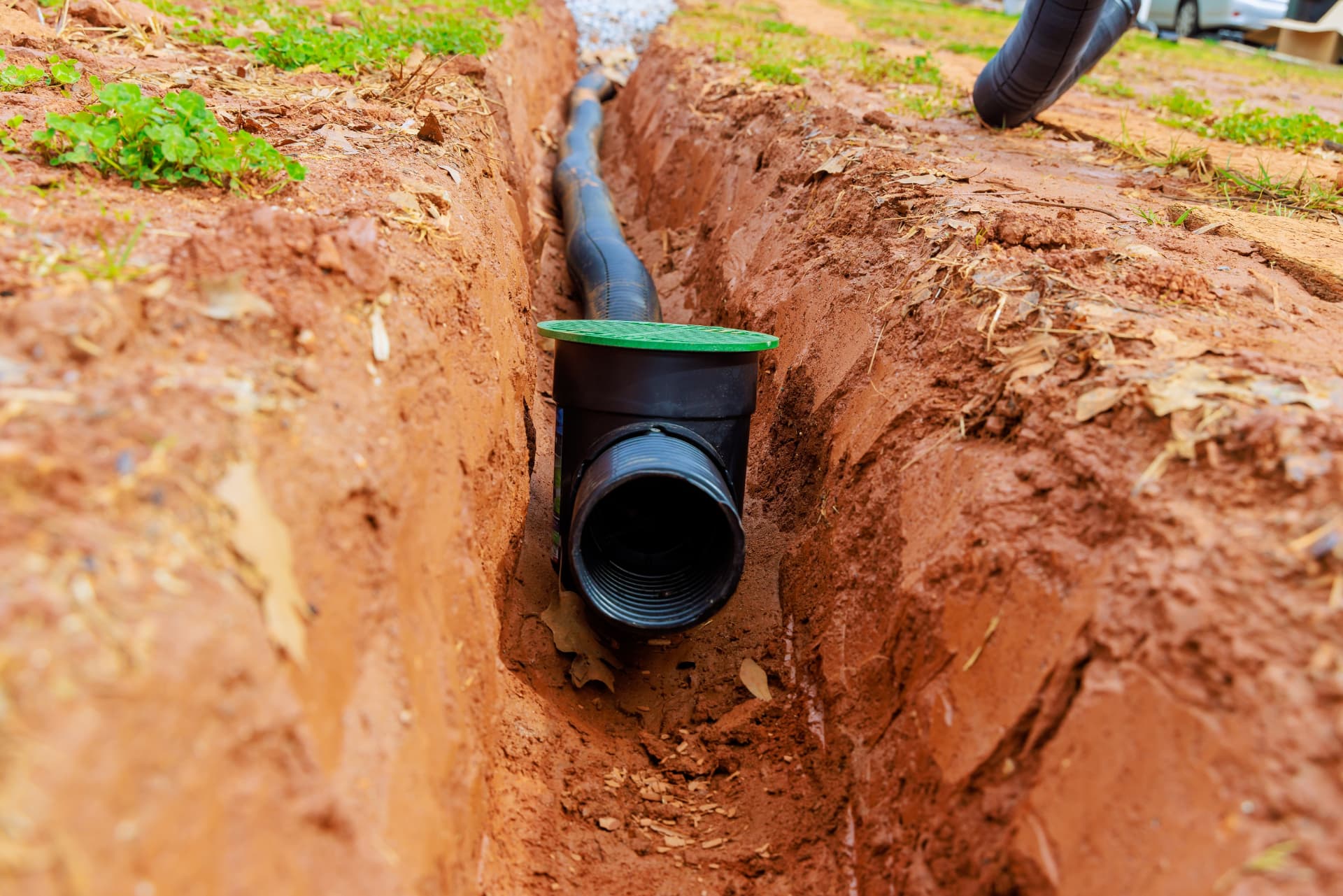 Drainage pipe bedded into a freshly excavated trench