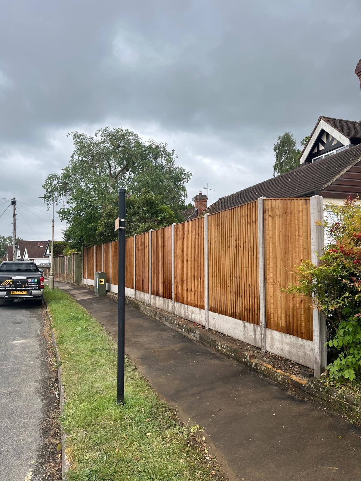 Timber fence panels with concrete posts installed along a boundary