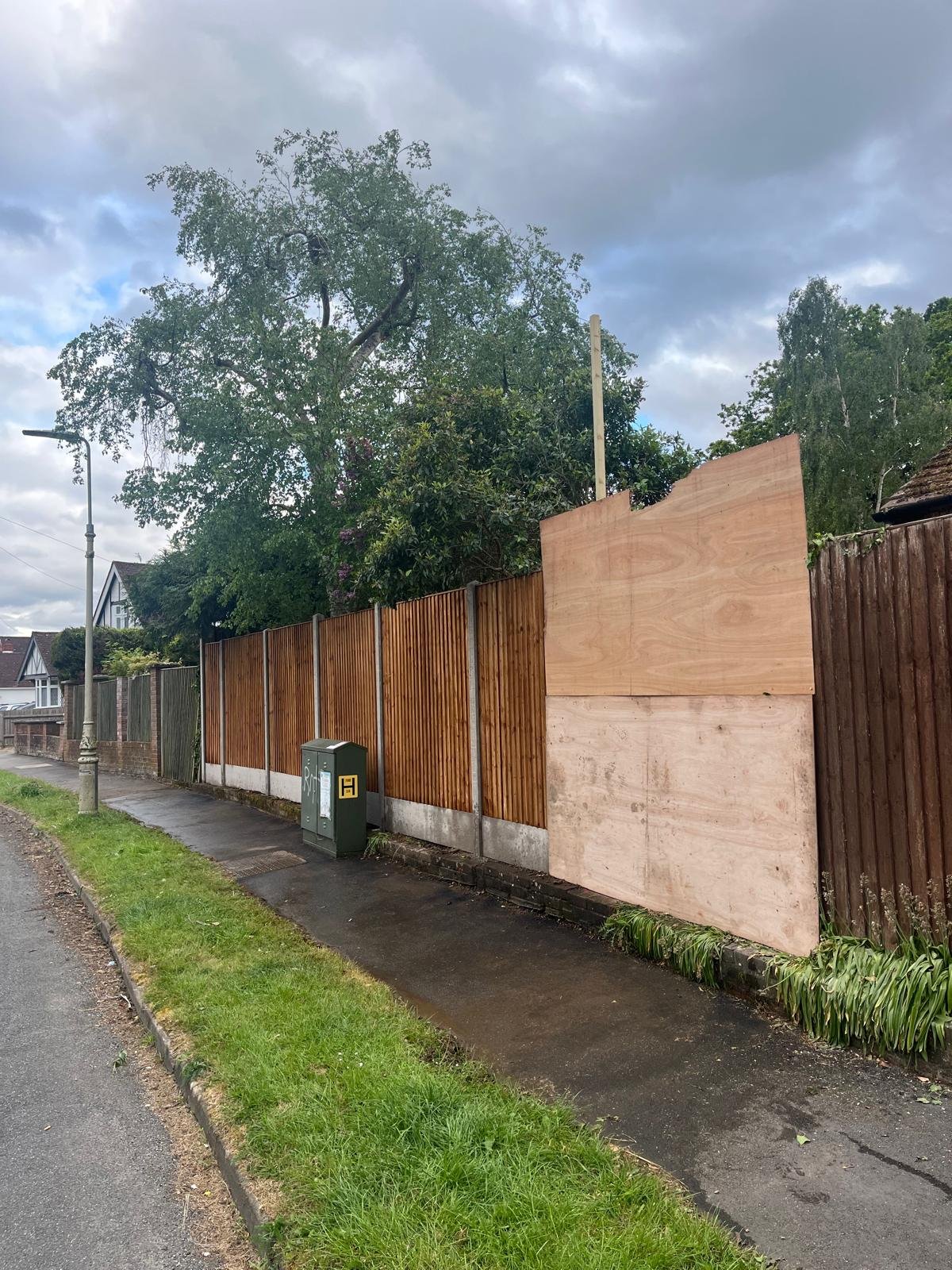 Damaged boundary fence boarded with plywood before replacement by John Ruben Ltd in Potters Bar