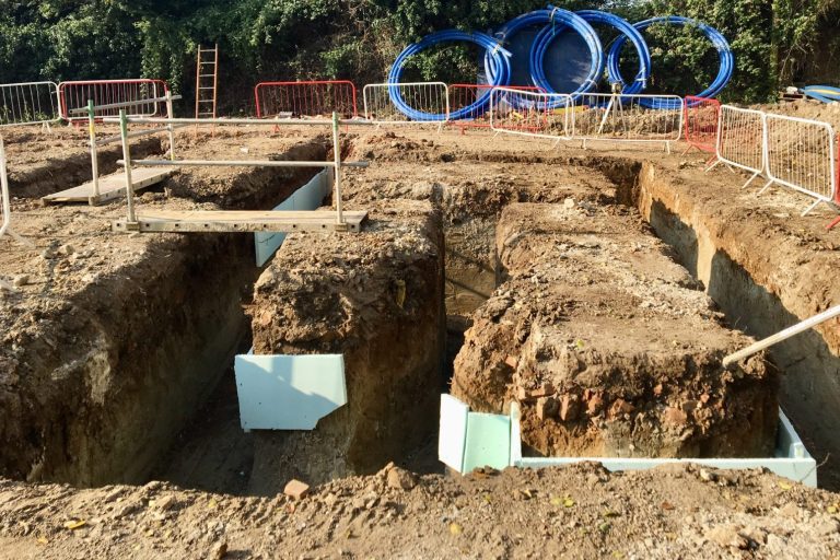 Groundworks excavation with foundation trenches and utility pipes